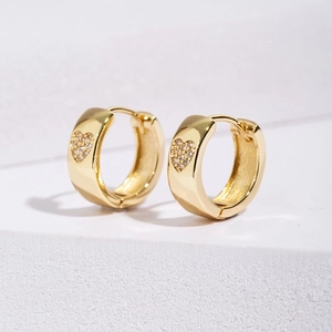 Macro detail of gold plated heart hoop earring with micro-paved sparkling cubic zirconia
