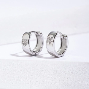 Macro view of wide hoop earrings with micro-inlaid heart zircon stones in silver