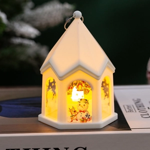 Macro view of white Christmas lantern featuring a snowman and reindeer with warm LED light