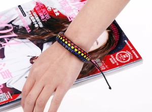 Detail of multi-layer woven leather bracelet with adjustable drawstrings on a model wrist