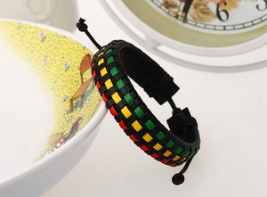 Close-up of woven leather Rastafari bracelet with adjustable sliding knot on a white bowl