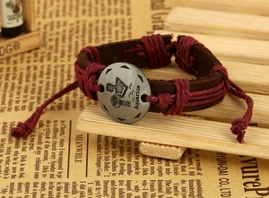 Close-up of woven leather Aquarius bracelet with round metal zodiac pendant and vintage theme