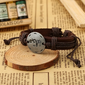 Detail of hand-woven brown leather Virgo zodiac bracelet on a rustic wooden base