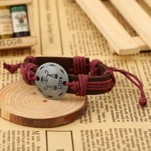 Macro shot of Libra constellation leather bracelet with vintage metal disc detail