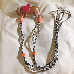 Detail of leather elephant phone strap with checkered lanyard and adjustable buckle