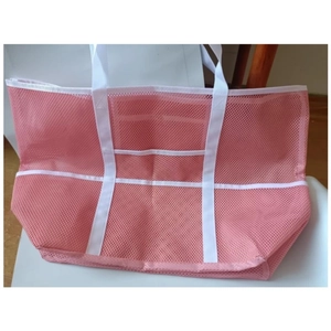Pink mesh beach bag with white straps featuring 9 pockets for travel and bath essentials