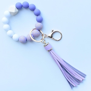 Macro detail of purple silicone leopard beads and wood bead keychain with PU tassel