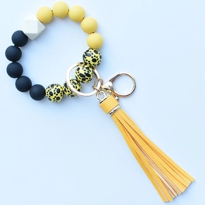 Close-up of leopard print silicone beads wristlet with yellow PU tassel and gold hook