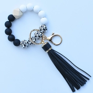 Close-up of silicone beaded keychain bracelet with wood bead and black tassel detail
