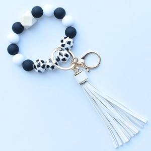 Detail of leopard print silicone beads bracelet with wood bead and white PU tassel