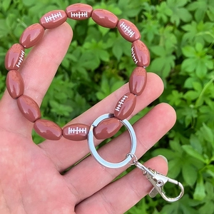Detail of beaded American football keychain wristlet with silver metal ring and lobster clasp
