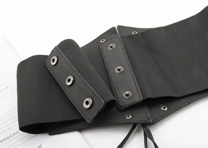 Vintage black elastic corset belt with metal buckles and lace-up detail on white background
