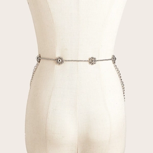 Layered silver metal waist chain with 3D floral accents for women on a beige mannequin