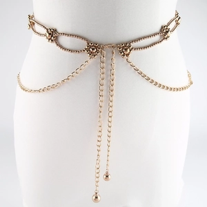 Chic layered golden metal waist chain belt with beads on white mannequin torso