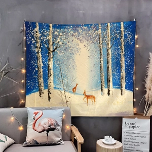 Detail of winter forest tapestry with reindeer and fairy lights in a cozy living room