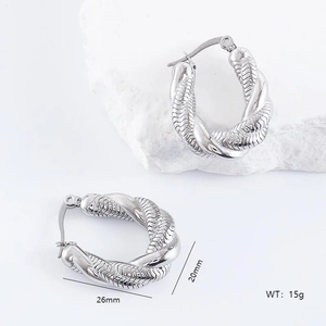 Irregular silver stainless steel serpent hoop earrings displayed on a white stone block