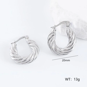 Macro detail of 20mm irregular twisted silver hoop earrings with a mirror-polished finish