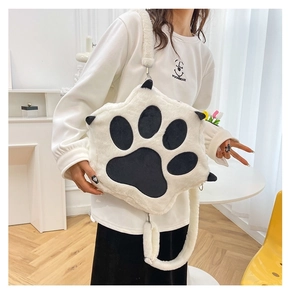 Detail of soft white plush cat paw crossbody bag featuring black pads and fuzzy strap