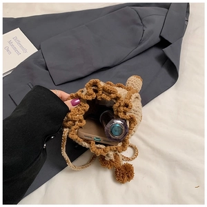 Detail showing inner capacity of beige knitted bear bag with drawstring and phone