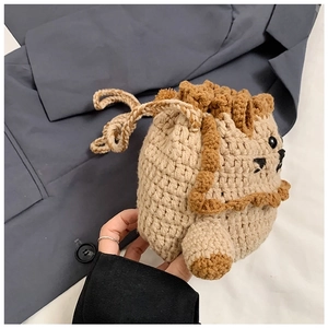 Detail of handmade crocheted lion drawstring bag showing yarn texture and lion mane design