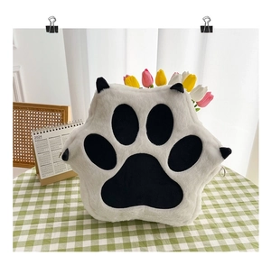 Close-up of a white plush cat paw backpack on a green checkered table with tulips