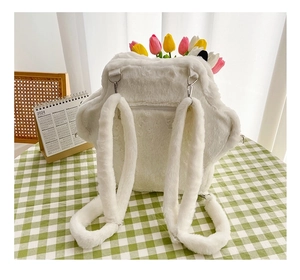 Detailed view of a white star-shaped plush backpack with thick fuzzy straps and metal hooks