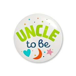 Detailed close-up of Uncle to Be tinplate badge for baby shower gender reveal party