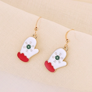 Detail of gold metal Christmas glove earrings with white enamel and green snowflake patterns