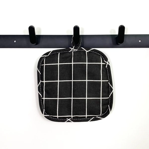 Detail of square black checkered fabric pot holder with a hanging loop on hook