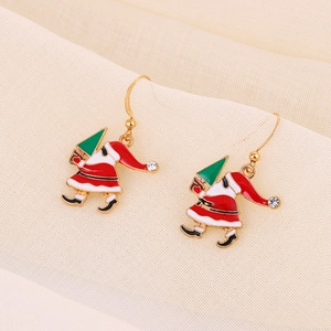 Detailed macro of Santa Claus earrings with a green Christmas tree and red enamel finish
