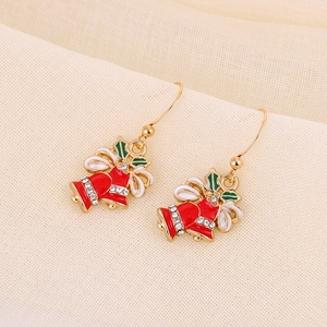 Detail of Christmas bell earrings with red bows, holly leaves and crystals on gold alloy