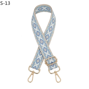 Detail of blue and white ethnic woven bag strap with golden metal lobster clasps