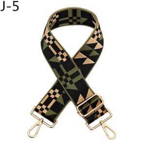 Close-up of wide geometric woven bag strap with golden metal hooks and adjustable buckle