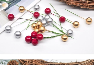 Macro detail of red, gold, and silver festive foam berries with wire stems for DIY crafts