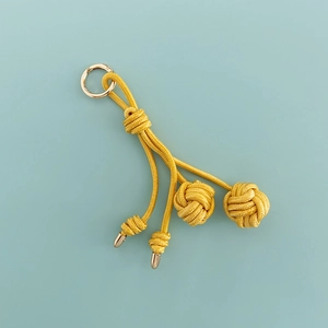 Detailed shot of a yellow hand-woven volleyball bag charm with nylon rope and metal ring