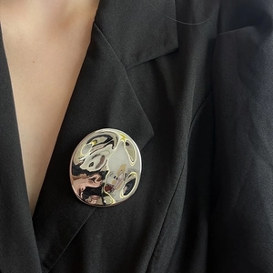 French vintage silver irregular wavy round brooch on black suit jacket lapel