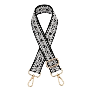 Detail of adjustable ethnic style bag strap with black and white embroidery and gold clips