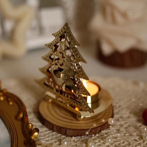 Golden hollow metal Christmas tree candle holder with reindeer on rustic wood base