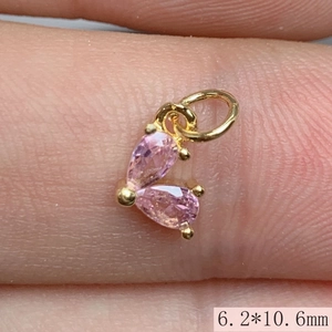 Detailed macro view of 6.2x10.6mm gold heart pendant with pink cubic zirconia