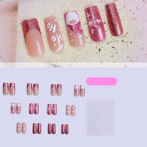 Christmas press-on nails featuring pink glitter and Santa motifs with HO HO lettering