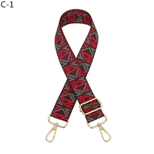 Close-up of ethnic geometric pattern webbing with light gold lobster claw buckles