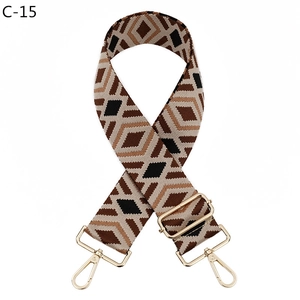 Detail of adjustable wide shoulder strap with brown geometric diamond pattern and gold hardware