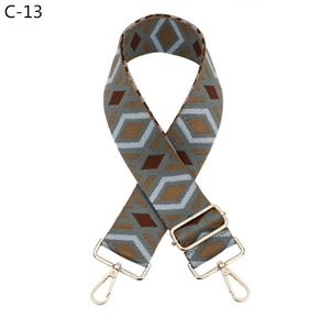 Close-up of geometric diamond pattern shoulder strap with gold metal lobster swivel hooks