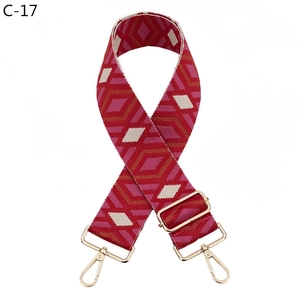 Detail of red and pink diamond pattern wide woven strap with gold metal buckles