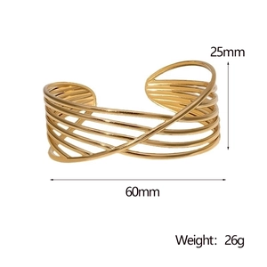 Macro shot showing 25mm width and 60mm diameter measurements of the gold crossover cuff