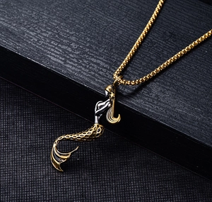 Detail of two-tone gold and silver mermaid pendant with intricate scale textures on a chain