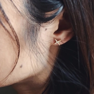 Minimalist S925 silver gold-plated star stud earrings worn on a female model's ear