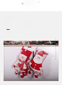 Close-up of plush Christmas stockings with 3D Santa and Snowman hanging on white cabinet