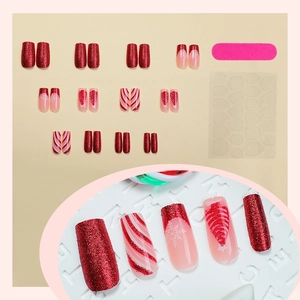 Christmas press-on nail kit with red glitter, snowflake, and tree designs on 24 tips