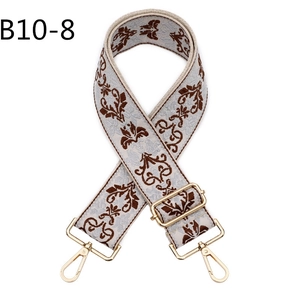 Close-up of vintage ethnic floral jacquard bag strap with gold metal lobster clasps